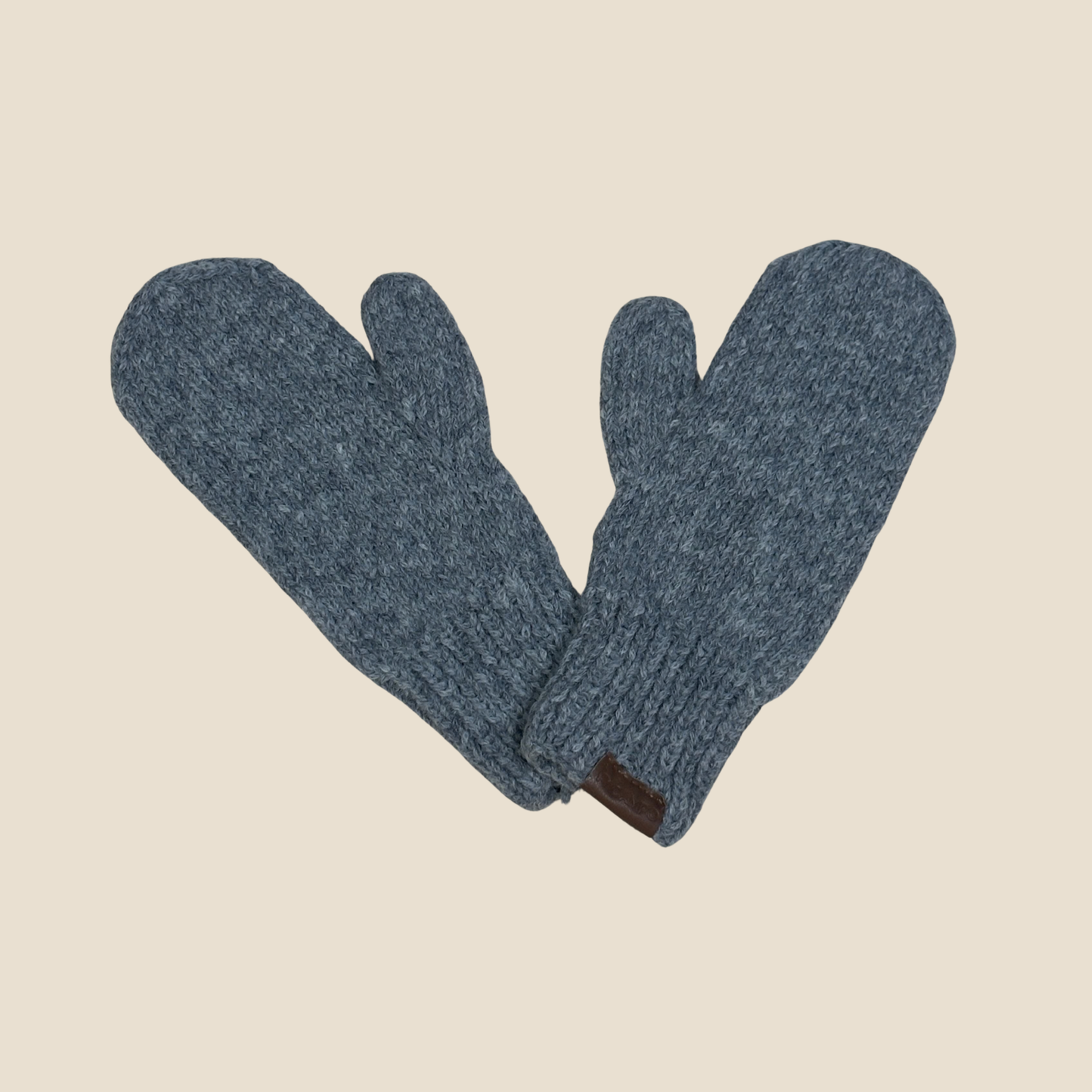 Pair of gray mittens on a beige background