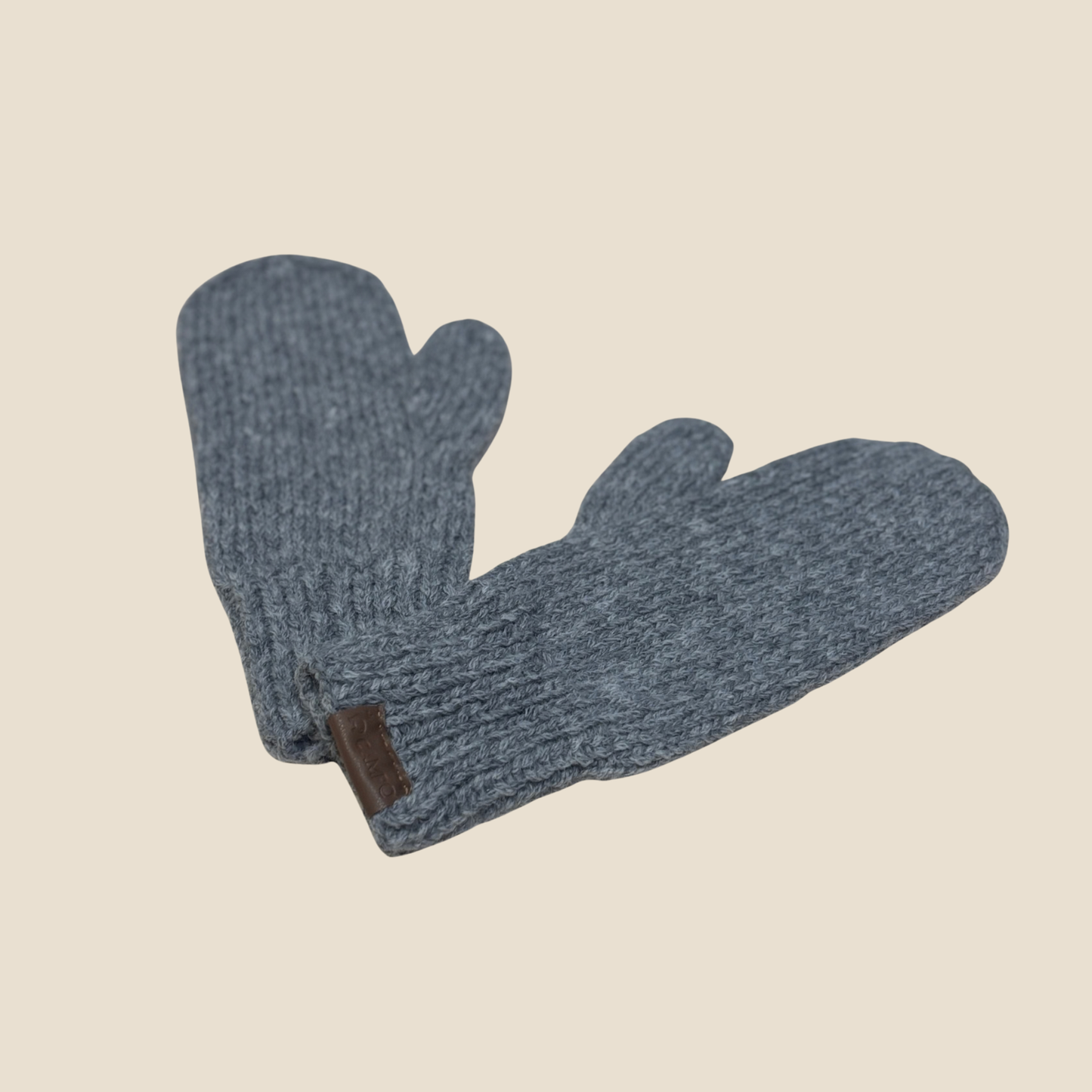 Pair of gray knit mittens on a beige background