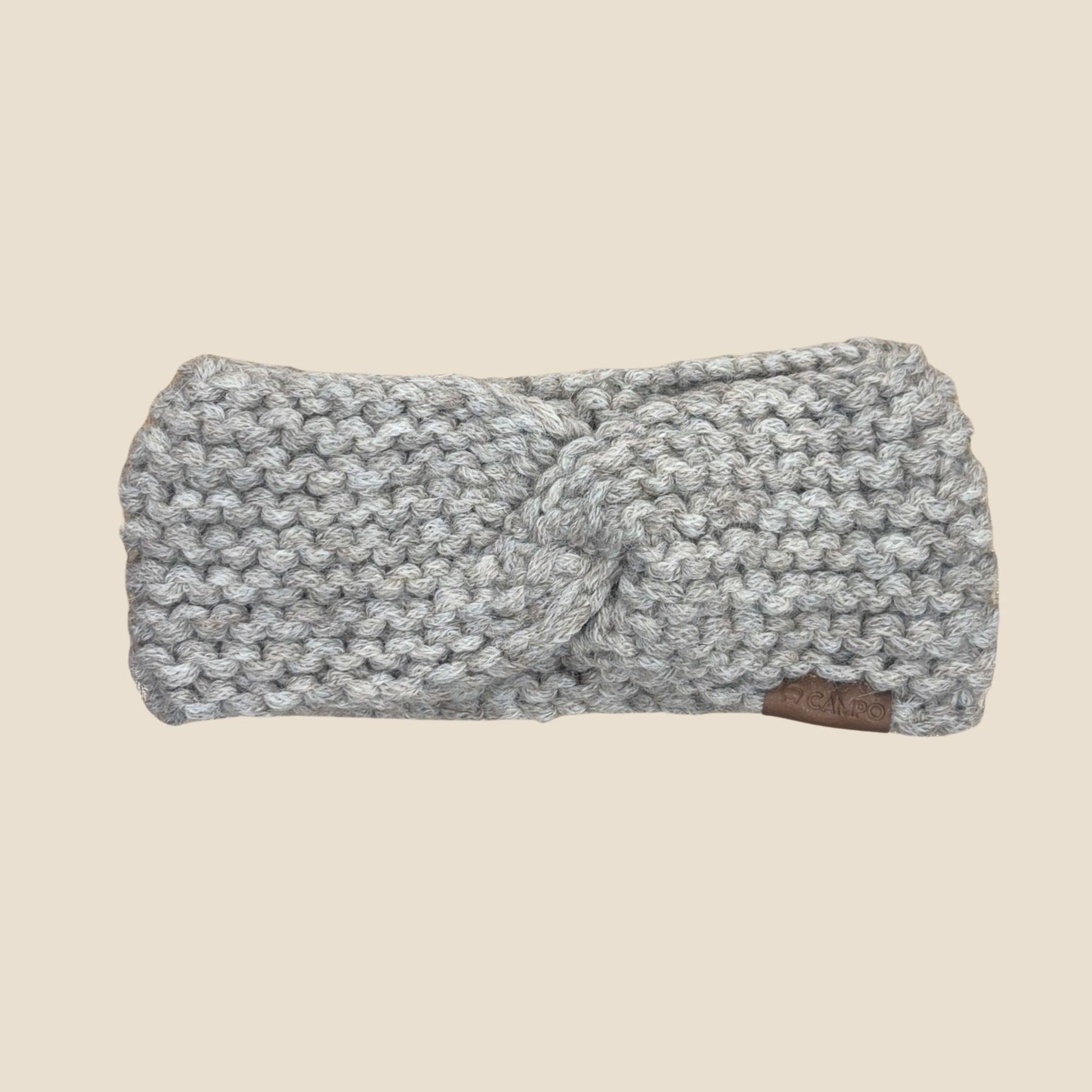 Oatmeal twisted headband with a knot on a beige background
