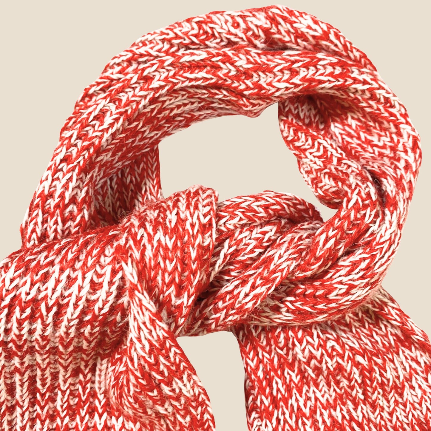 Close-up of a red and white braided rope on a beige background