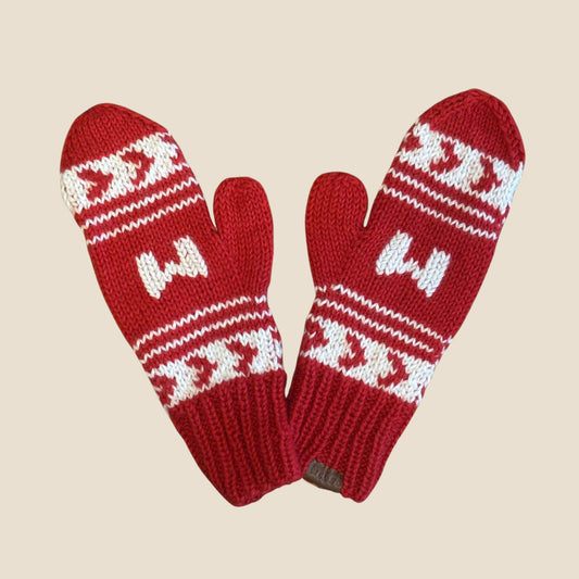 Red knitted mittens with white pattern on a beige background