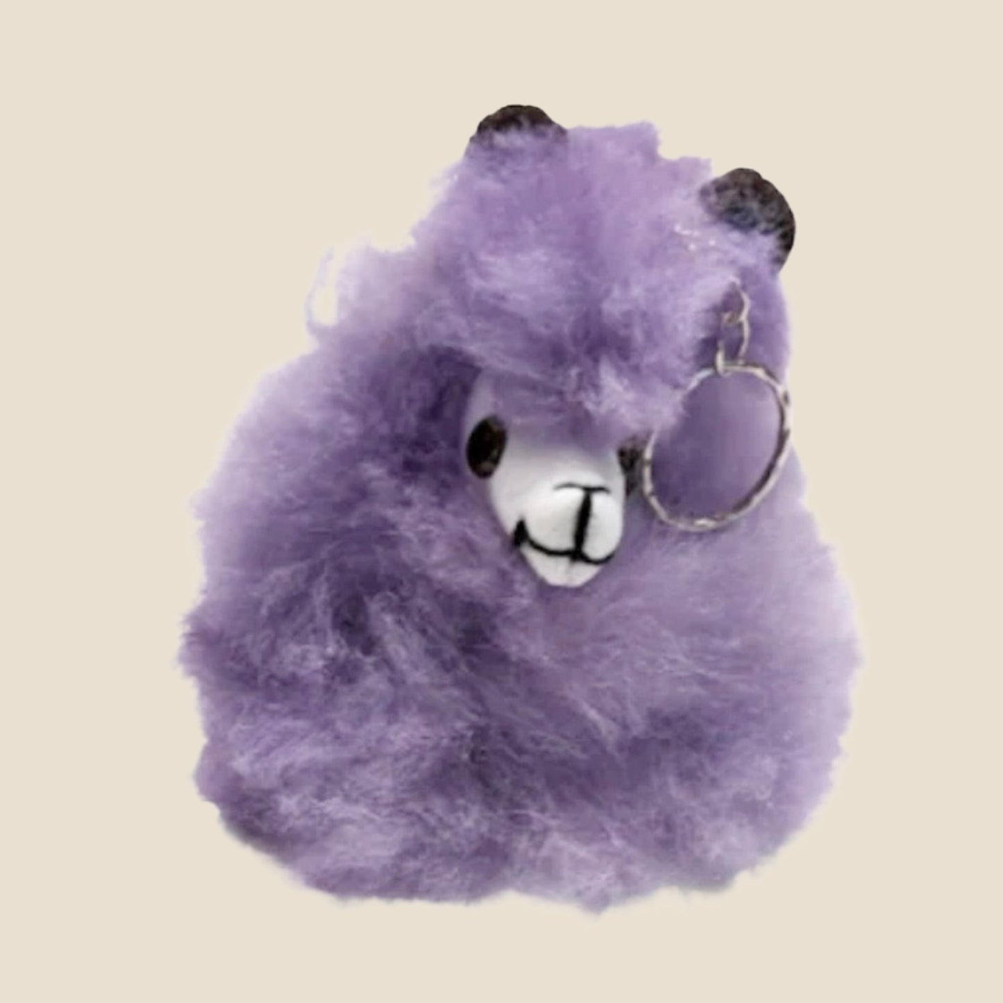 Purple plush toy with a keychain on a beige background