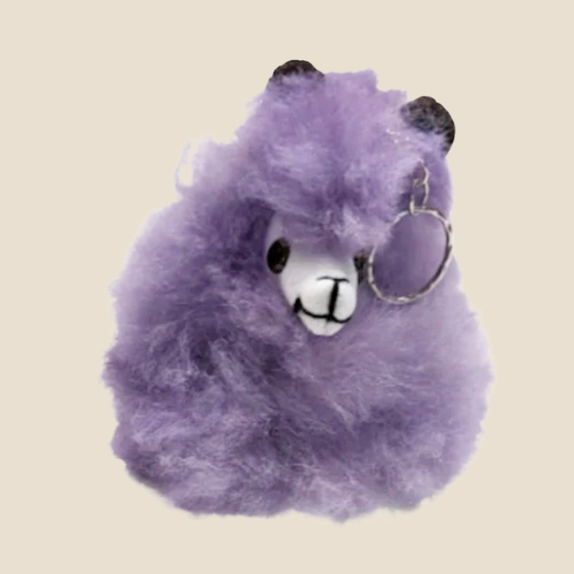Purple plush toy with a keychain on a beige background