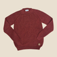 Maroon sweater on a beige background
