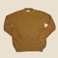 Brown sweater with a visible brand label on a beige background