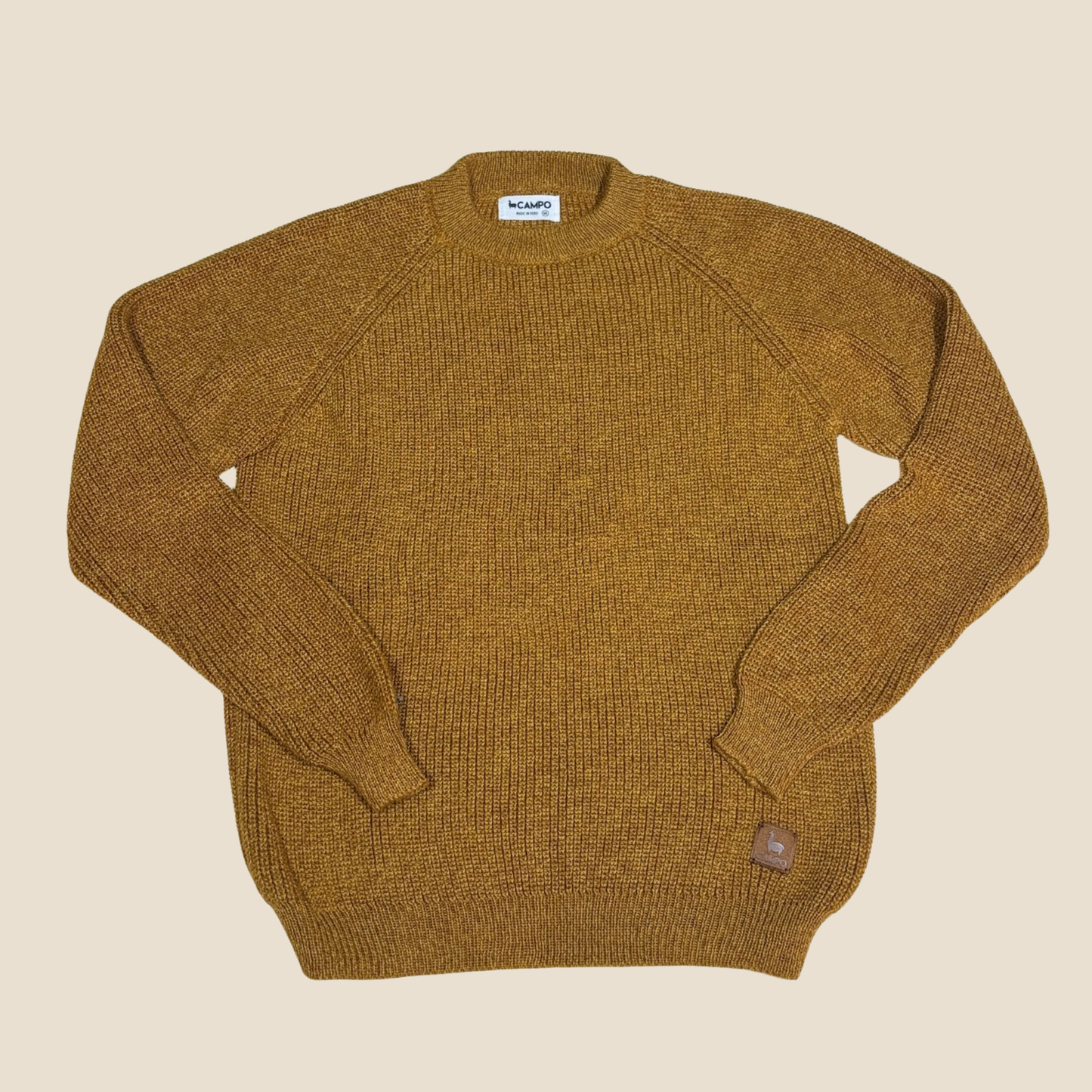 Brown sweater with a visible brand label on a beige background