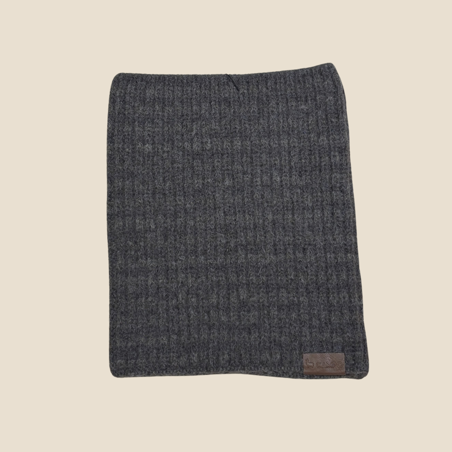 Gray textured blanket with a brand label on a beige background