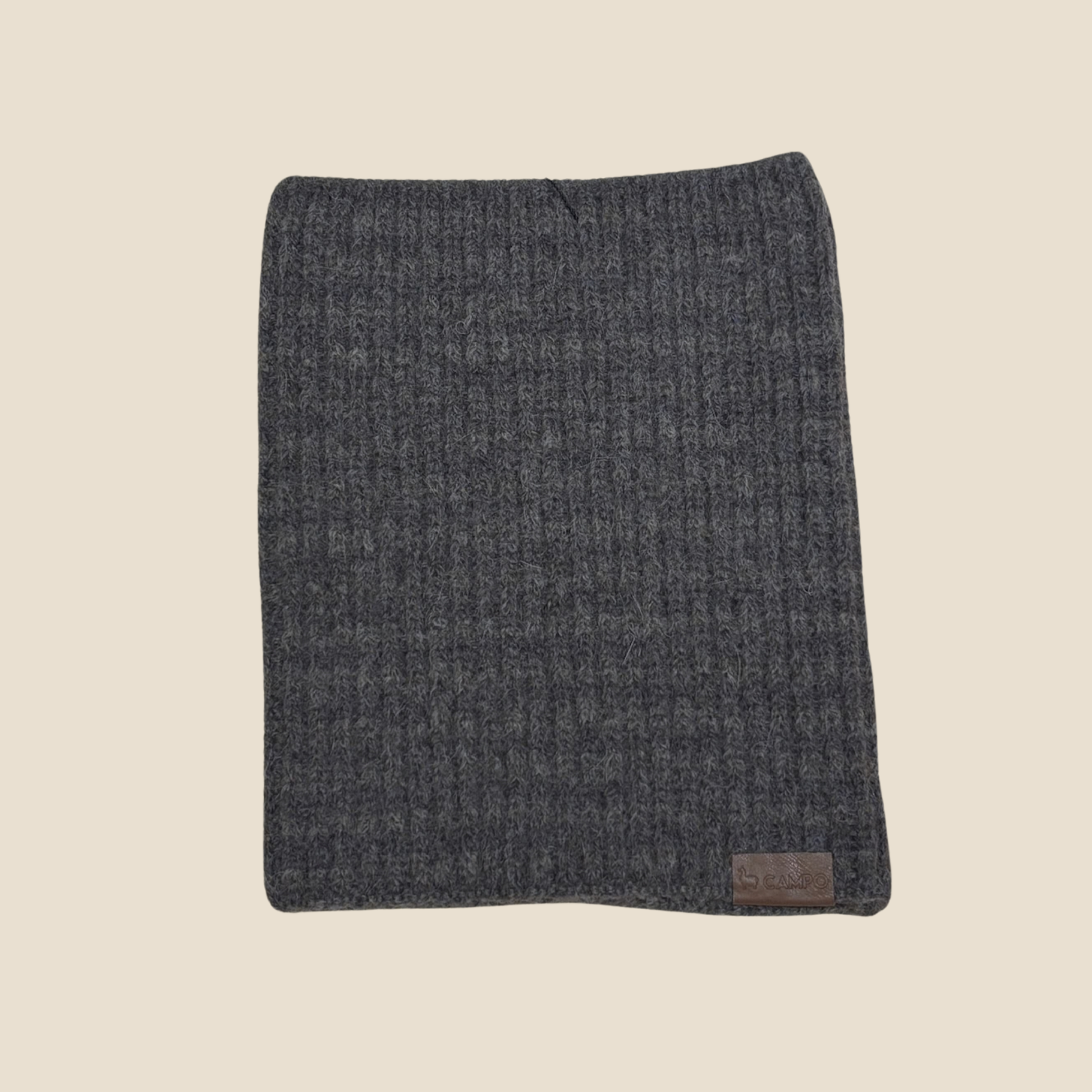 Gray textured blanket with a brand label on a beige background