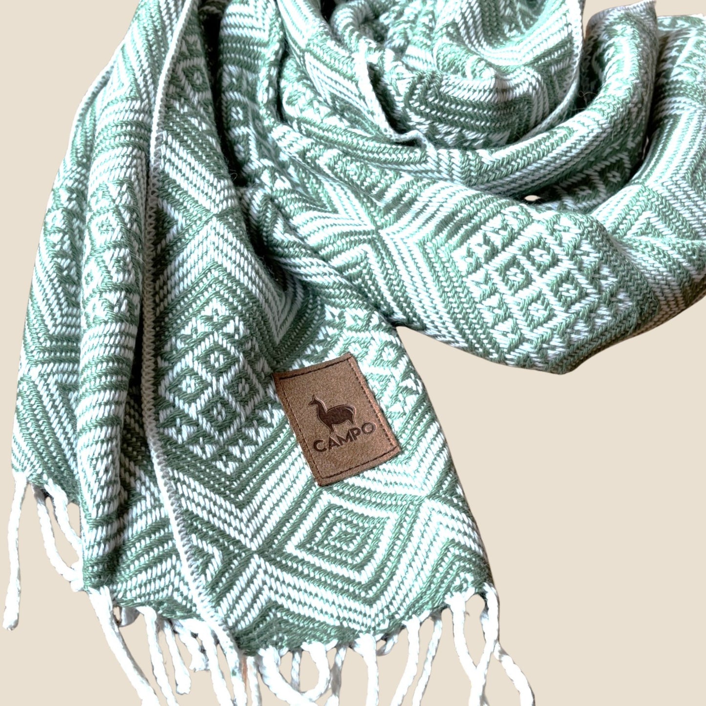 Sage patterned scarf with a brand tag on a beige background