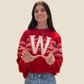 Person wearing a red sweater with a large 'W' on a beige background