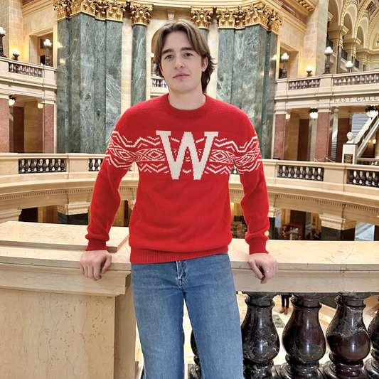 Person wearing a red sweater with a large 'W' in a historic building