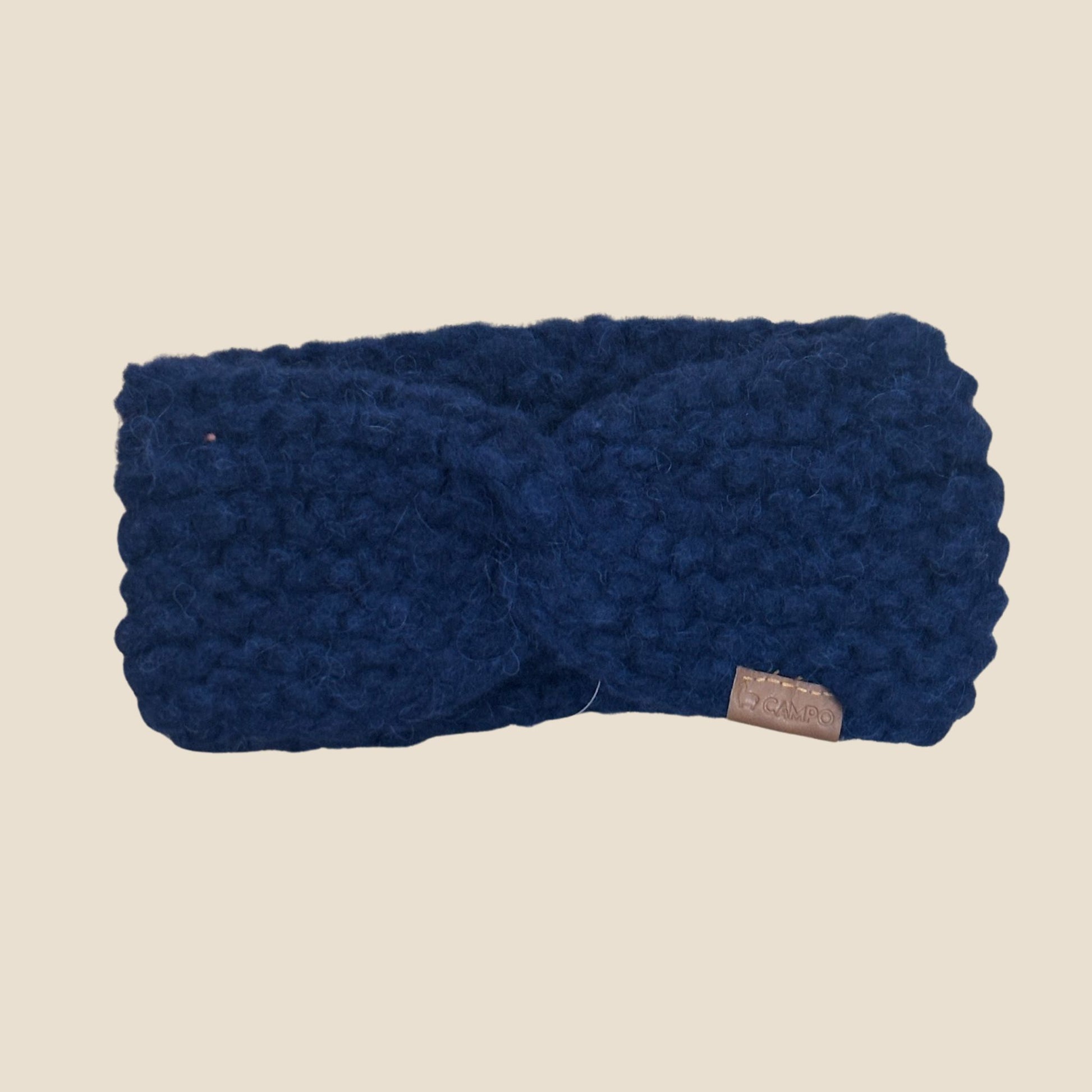 Dark blue twisted headband on a beige background