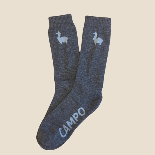 Pair of gray socks with alpaca design and 'Campo' branding on a beige background