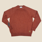 Brown sweater with brand labels on a beige background
