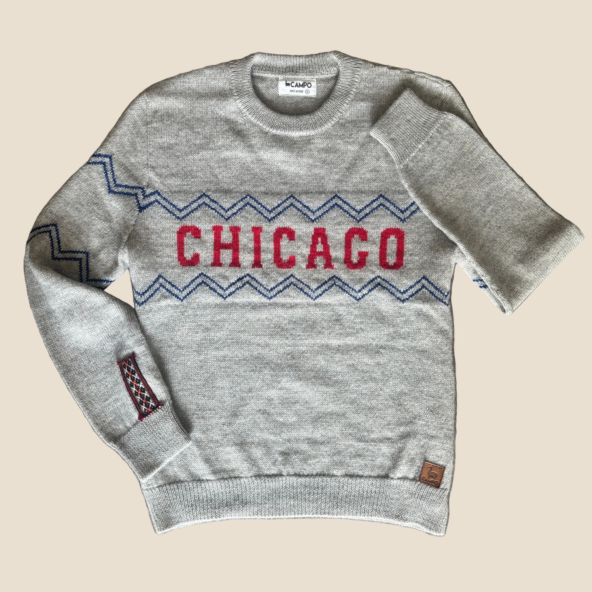Gray sweater with 'Chicago' design on a wooden surface