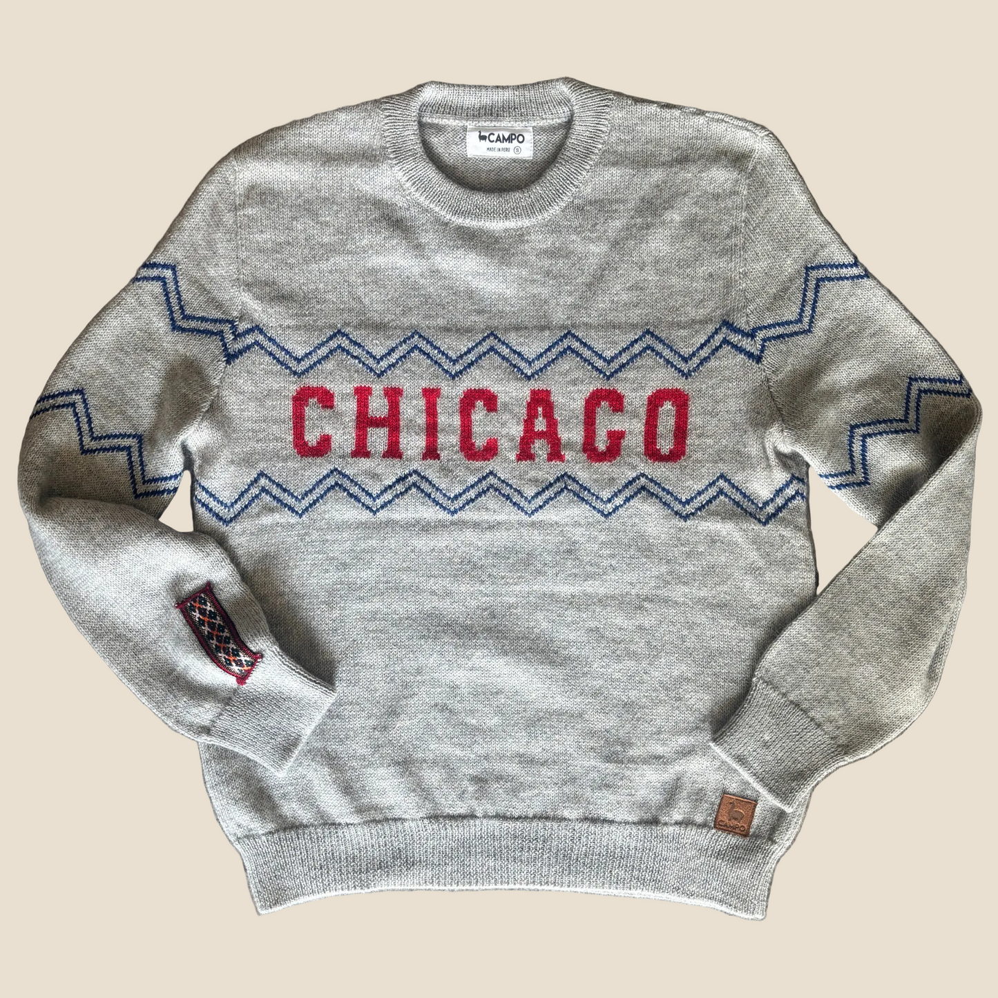 Gray sweater with 'Chicago' design on a wooden surface