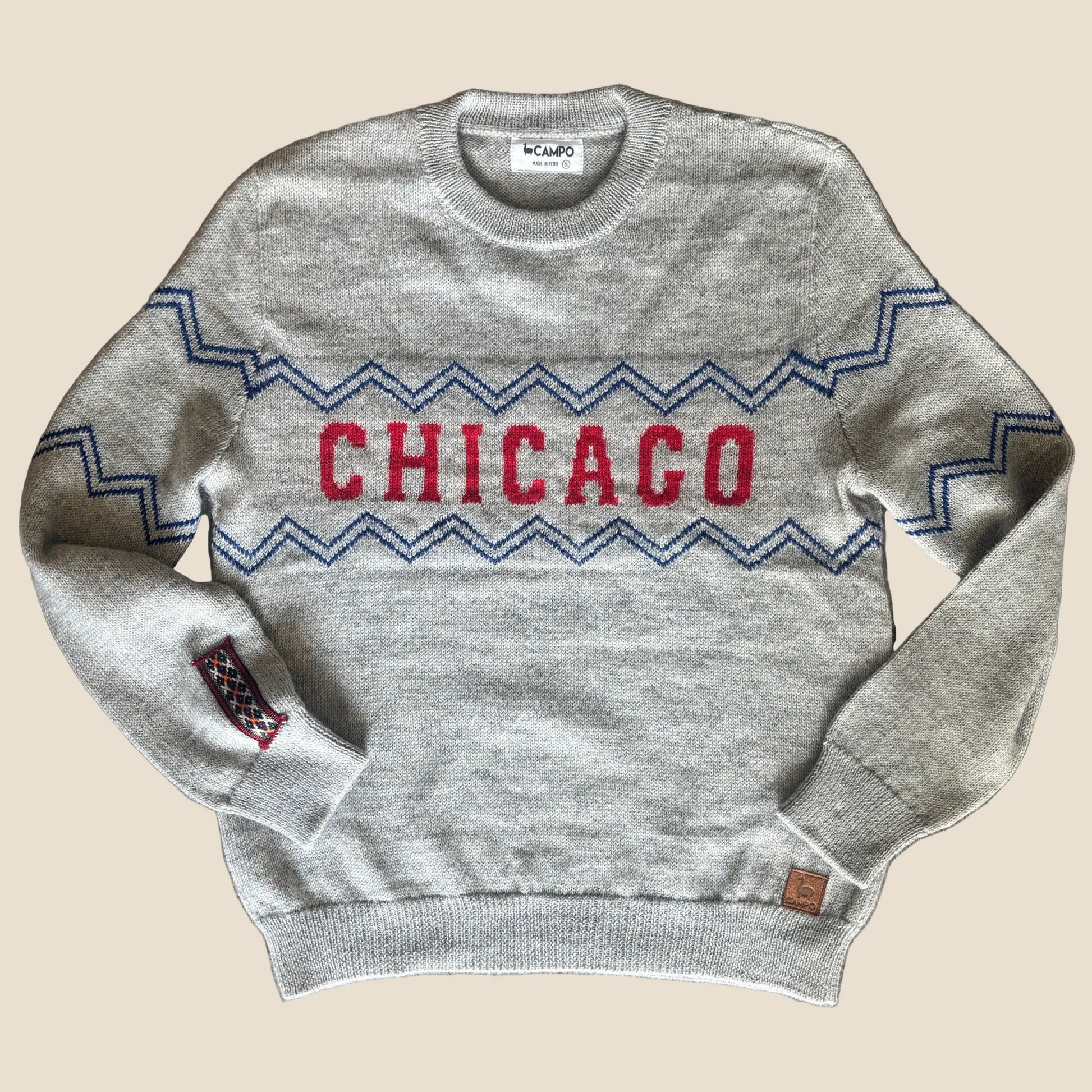 Gray sweater with 'Chicago' design on a wooden surface