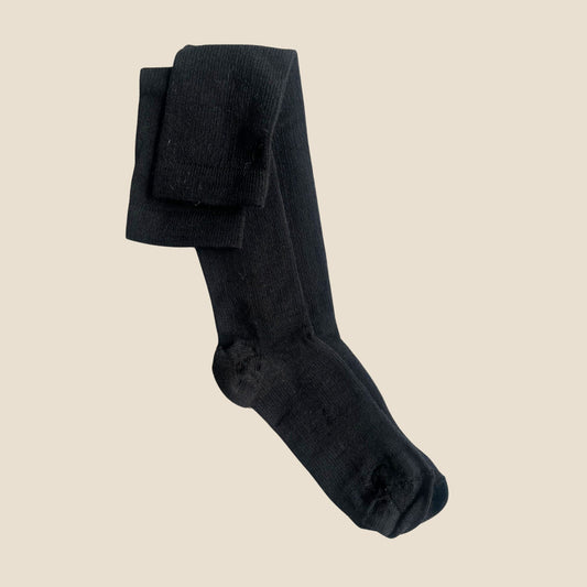 Black compression socks on a beige background