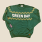 Green sweater with 'GREEN BAY' text on a beige background