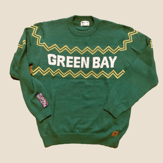 Green sweater with 'GREEN BAY' text on a beige background
