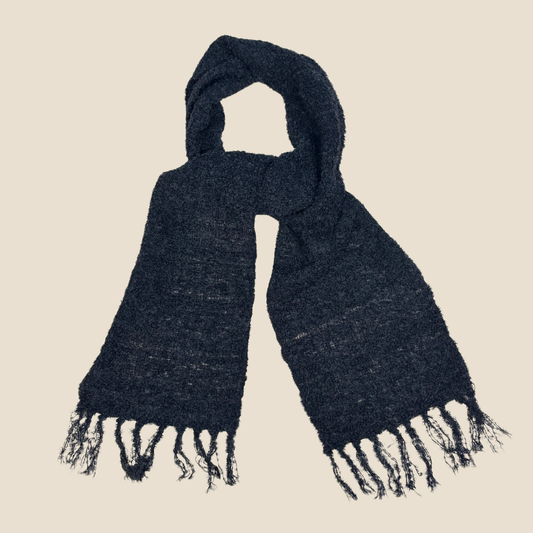 black scarf with fringes on a beige background
