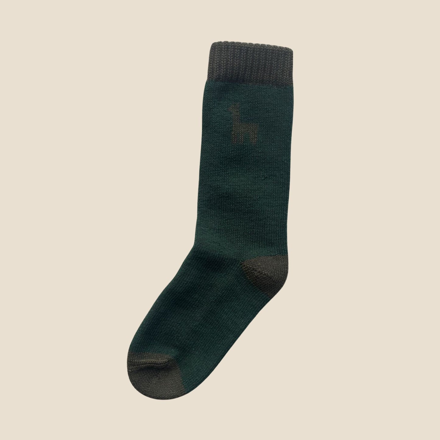 Green sock with dark accents on a beige background