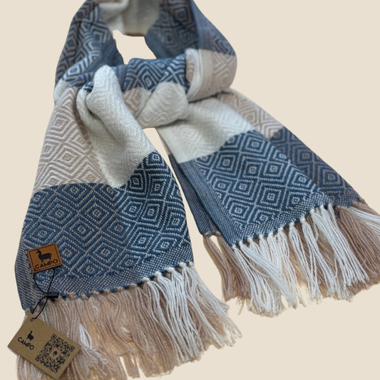 Blue and white patterned scarf with fringes on a beige background