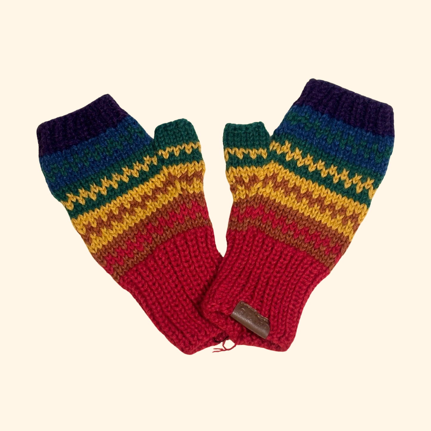 Pair of colorful knitted fingerless gloves on a beige background
