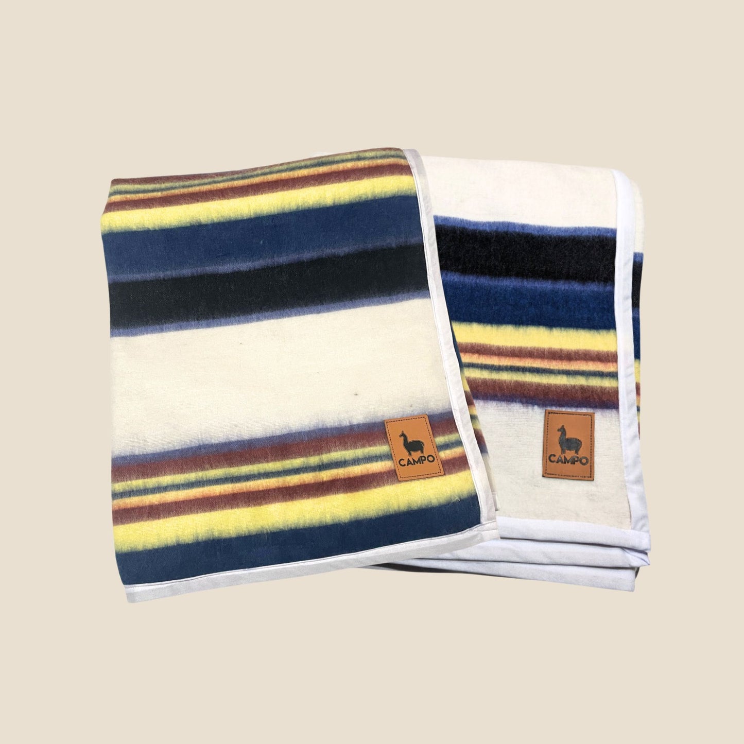 Striped blanket with colorful pattern and 'Campo' logo on a beige background