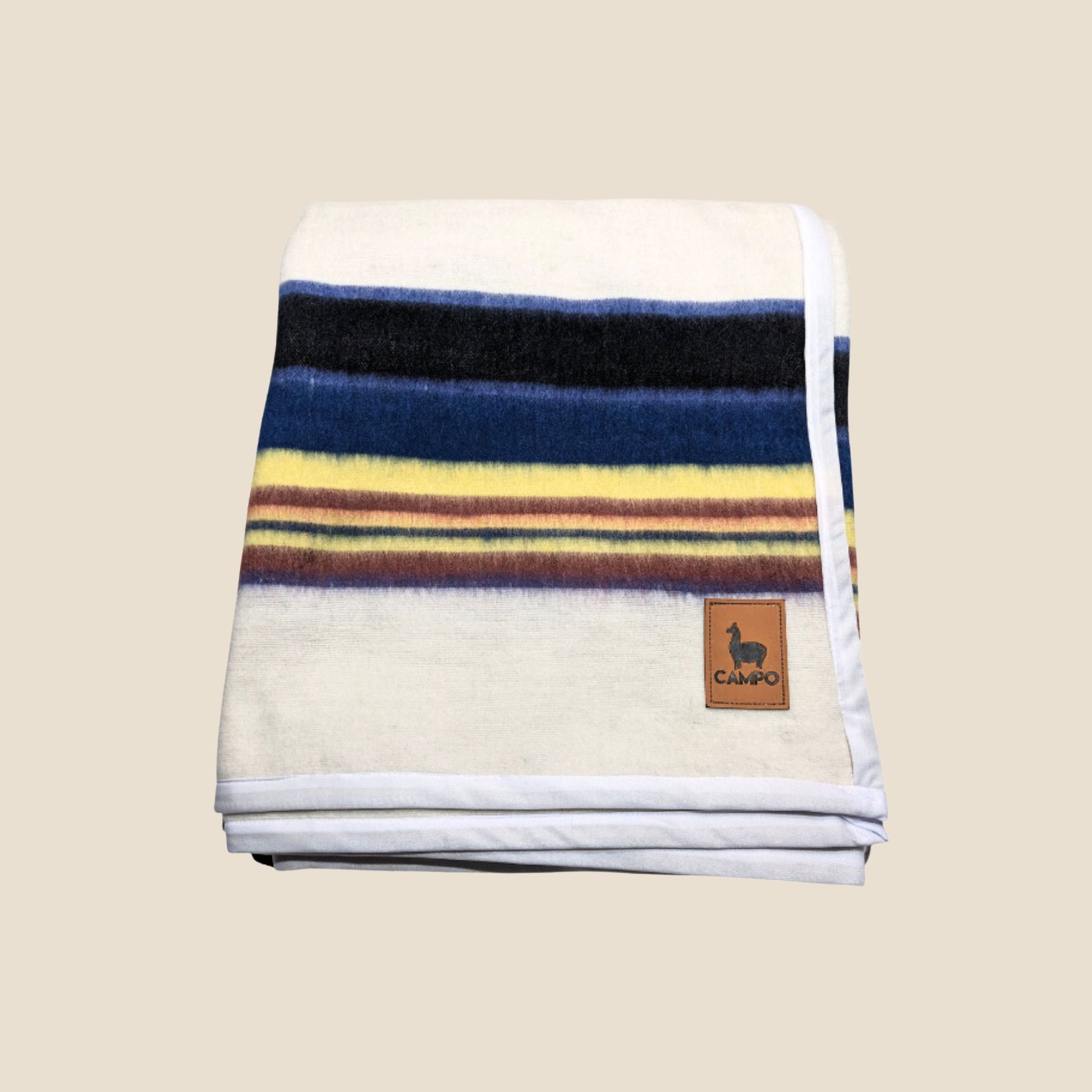 Striped blanket with a brand logo on a beige background