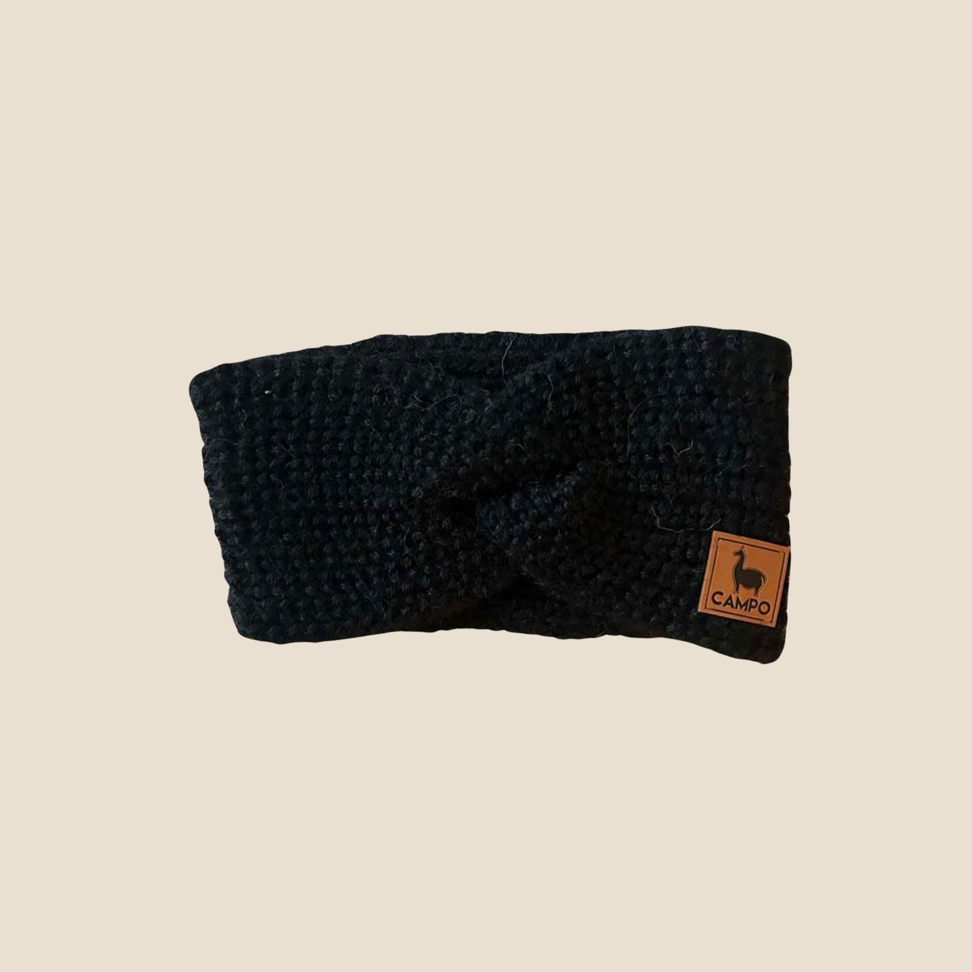 Black twisted headband with a 'Campo' label on a beige background