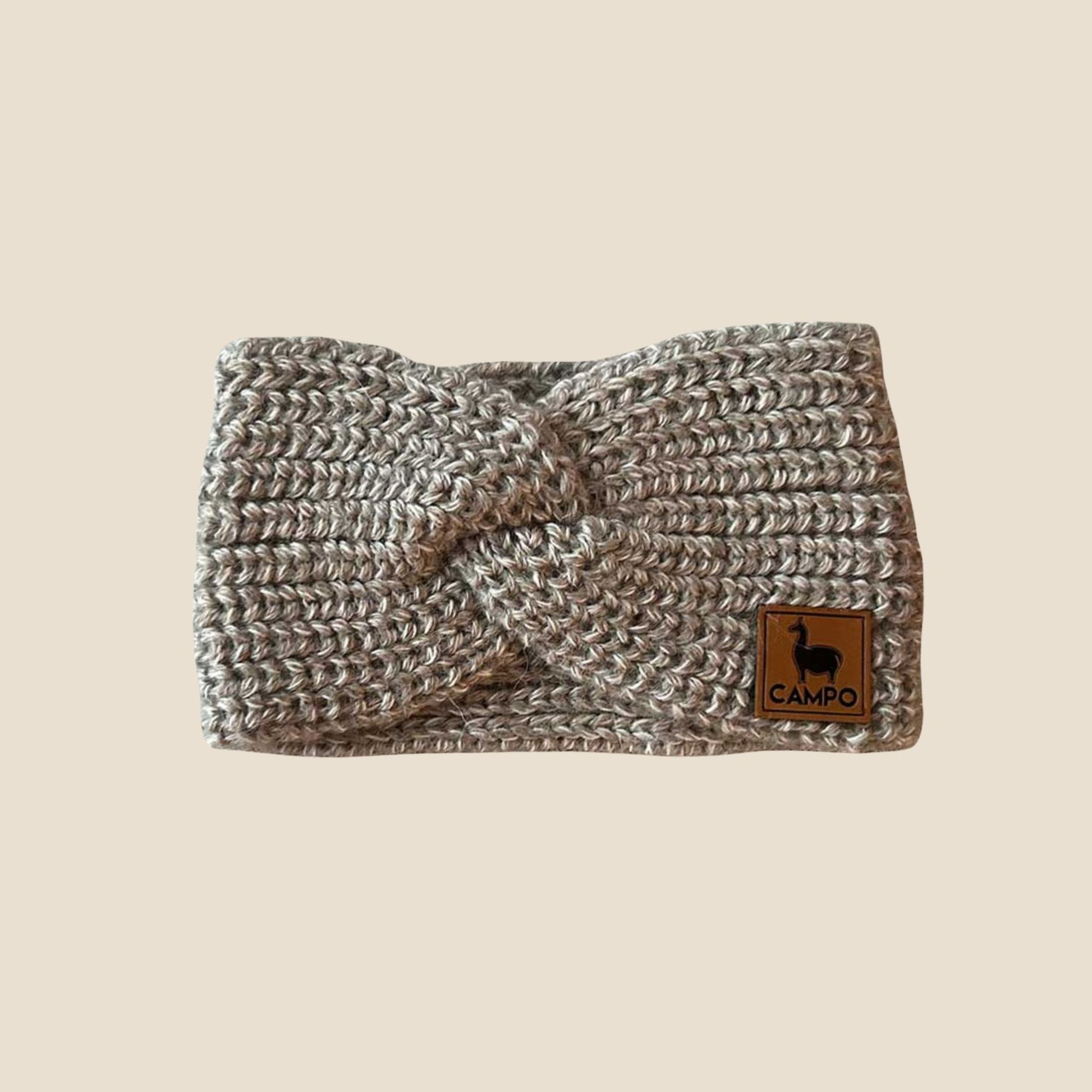 Oatmeal twisted headband with a 'Campo' logo on a beige background