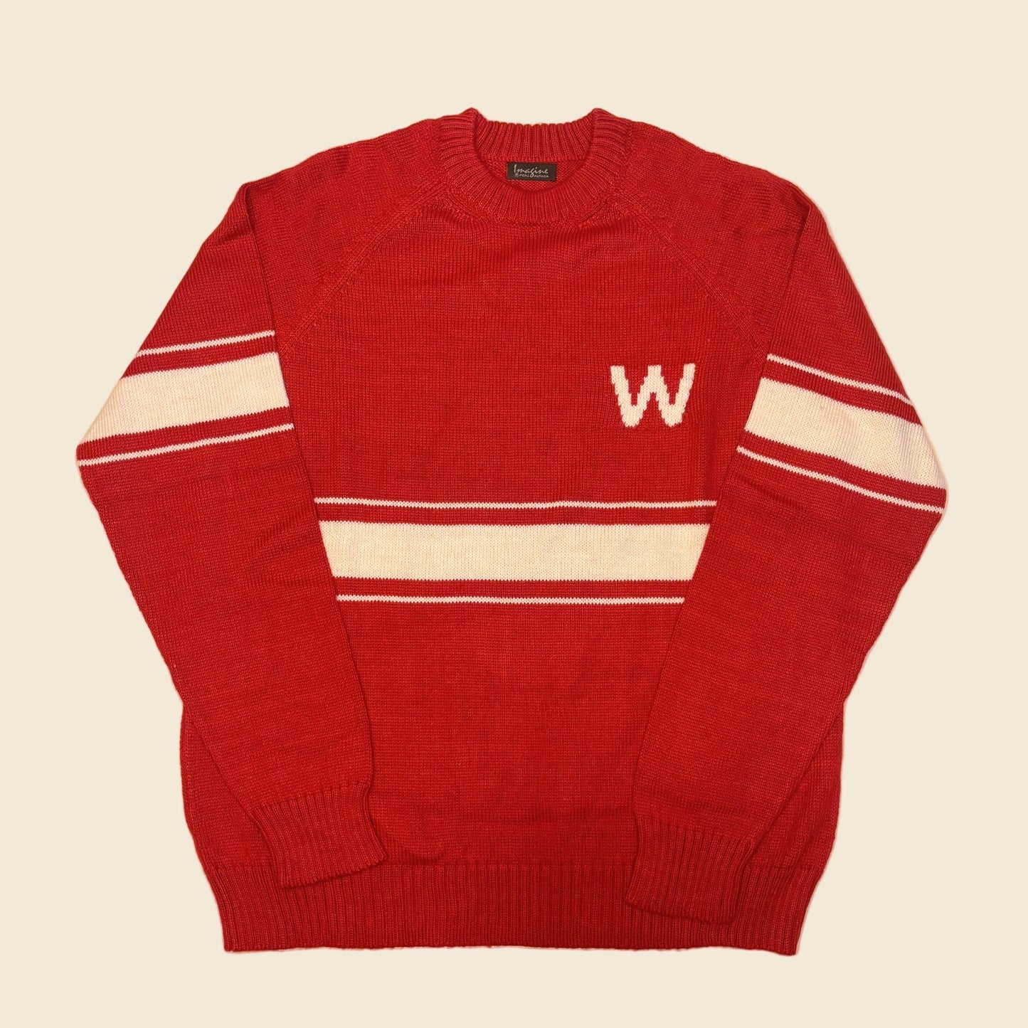 Red sweater with white stripes and a letter 'W' on a beige background