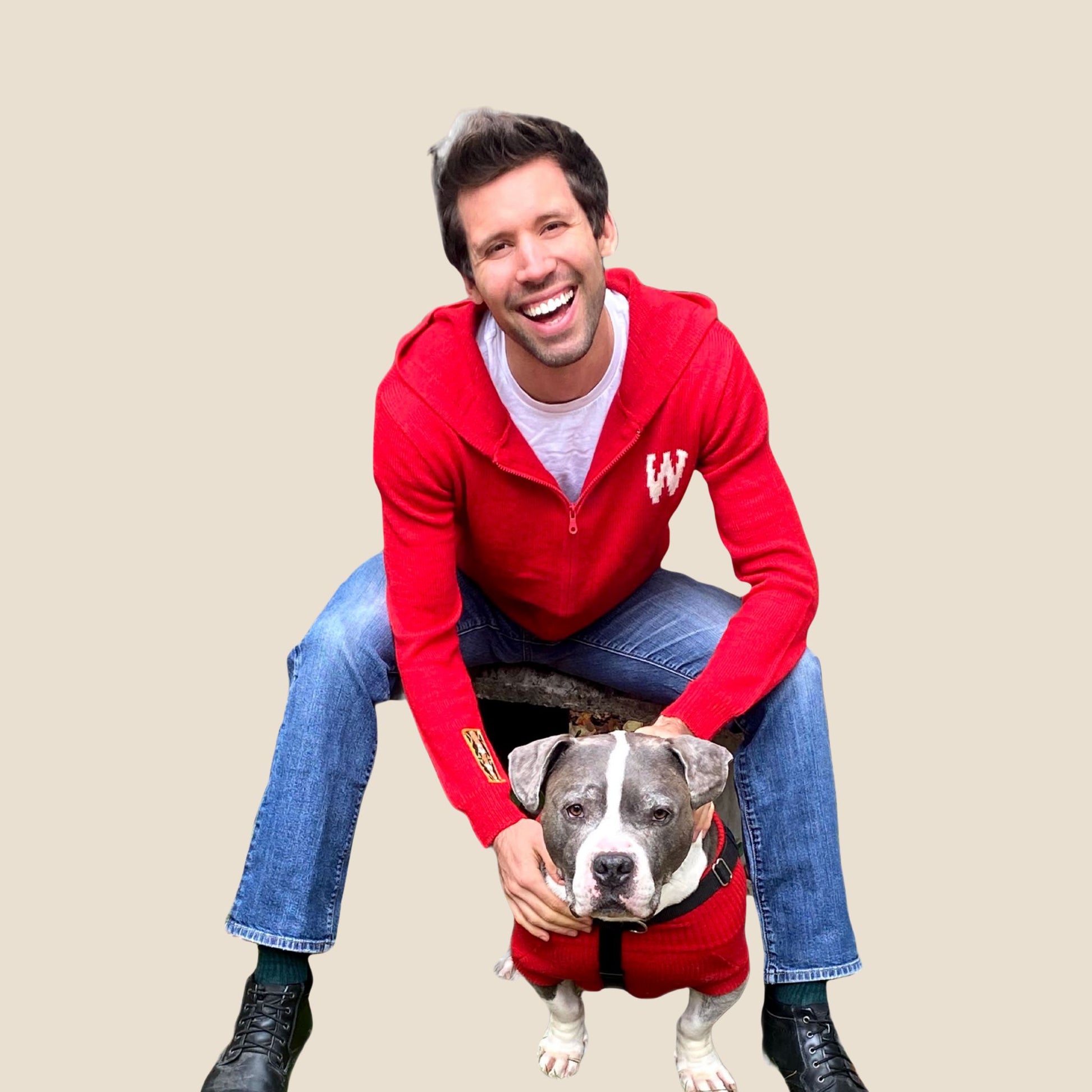 Man in a red hoodie with a dog on a beige background