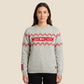 A woman modeling a light gray heather crewneck sweater with red and white zigzag patterns and 'WISCONSIN' printed across the chest in red, paired with black pants against a light gray studio background.